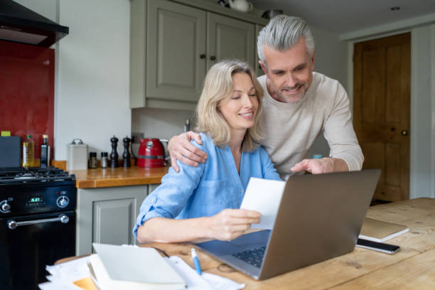istock Loving couple at home paying the bills online 1209687573