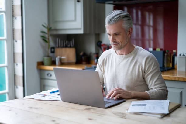 istock Adult man at home working on his laptop computer 1209687621