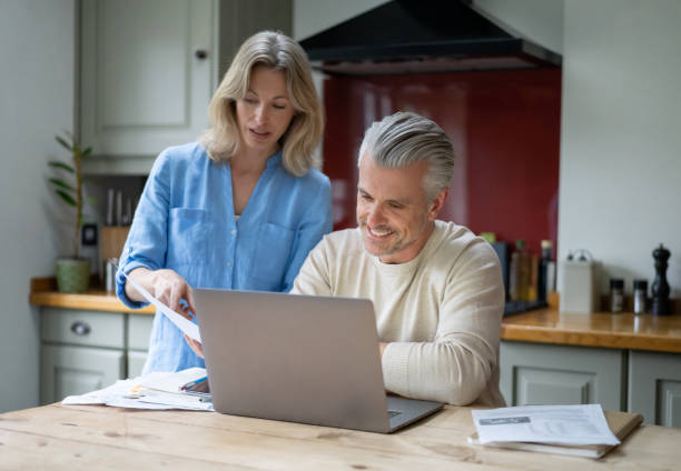istock Happy couple at home paying their bills online 1209687624