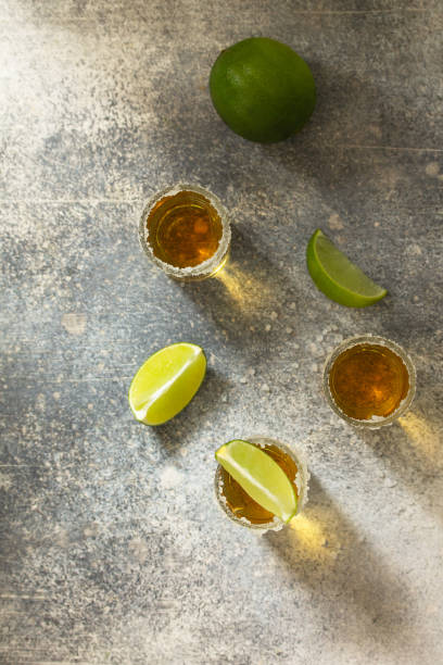 istock Gold Tequila. Mexican Gold Tequila shot with lime and salt on a stone light concrete worktop. Top view flat lay background. Copy space. 1209687643