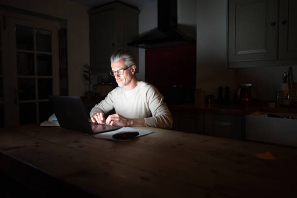 istock Man at home working online late at night 1209687831