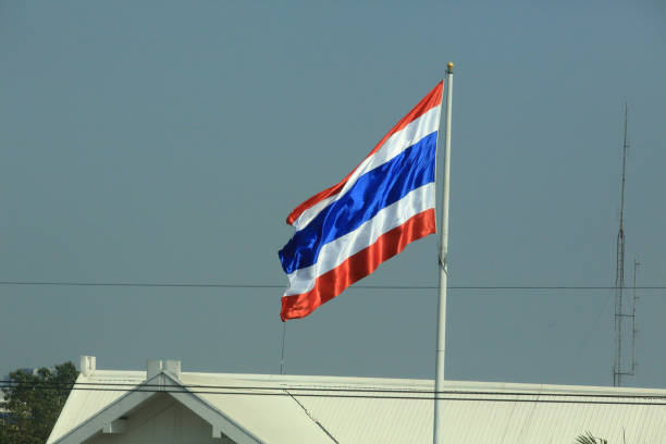 istock waving Thailand flag at outdoor, blue sky background 1209687883