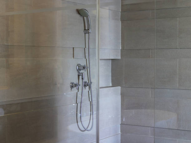 istock Shower faucet and head on wall with bath mirror enclosure 1209689591
