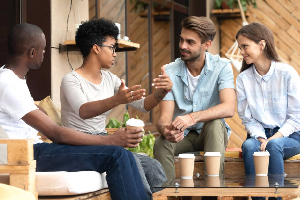 istock Diverse young people relax in cafe communicating 1209689702
