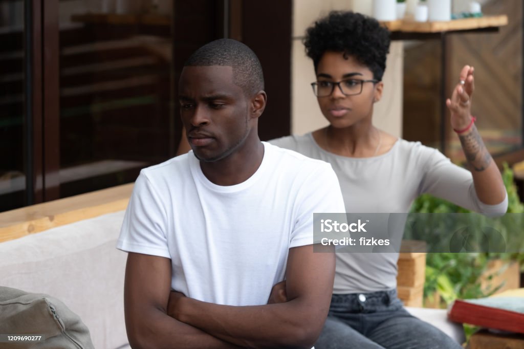 Black couple conflict in cafÃ© having relationships problems African American young couple sit outside having fight or misunderstanding conflict, black man ignore biracial girlfriend woman talking, female scold lecturing annoyed boyfriend. Relationships problem Adult Stock Photo