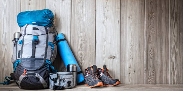 camping equipment, shoes, a backpack and a thermos on a wood background - tree stream forest woods imagens e fotografias de stock