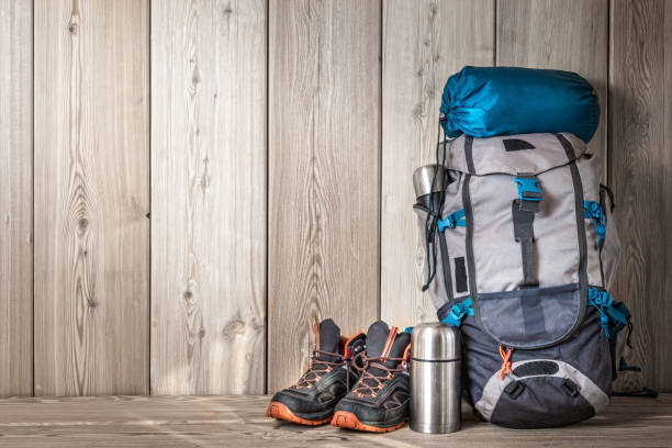 istock camping equipment, shoes, a backpack and a thermos on a wood background 1209695272