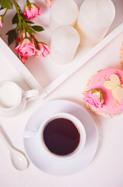 istock A cup of tea, pink roses and small cake on the white table 1209698768