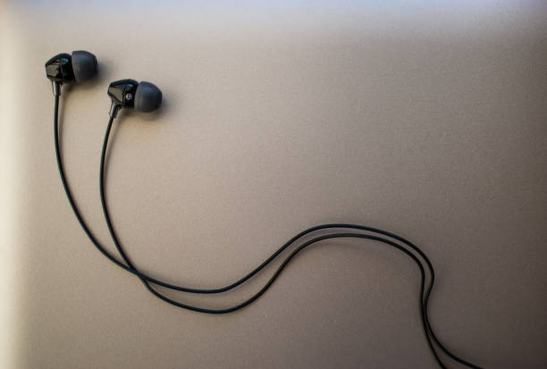 istock Black earphones on silver background 1209700131