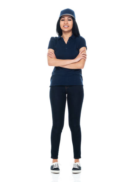 Latin american and hispanic ethnicity female delivery person standing in front of white background wearing jeans Full length of aged 20-29 years old who is beautiful with long hair latin american and hispanic ethnicity female delivery person standing in front of white background wearing jeans who is successful who is delivering with arms crossed woman wearing baseball cap stock pictures, royalty-free photos & images