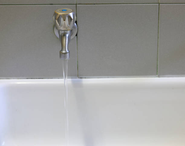 istock open tap with water above the ceramic sink 1209703685