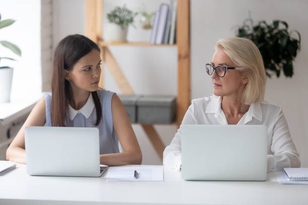 istock Different ages women colleagues looking with enmity at each other 1209703846
