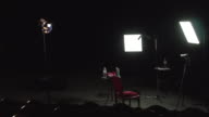 istock Documentary movie film set on theater stage three point lighting setup camera tripod director seat 1209704228