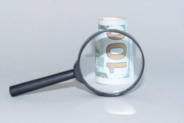 istock part of dollars under a magnifying glass, closeup. 1209706228