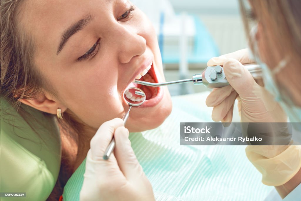 Girl Sitting At Dental Chair With Open Mouth During Oral Check Up While  Doctor Visiting Dentist Office Dentistry Concept Stock Photo - Download  Image Now - iStock