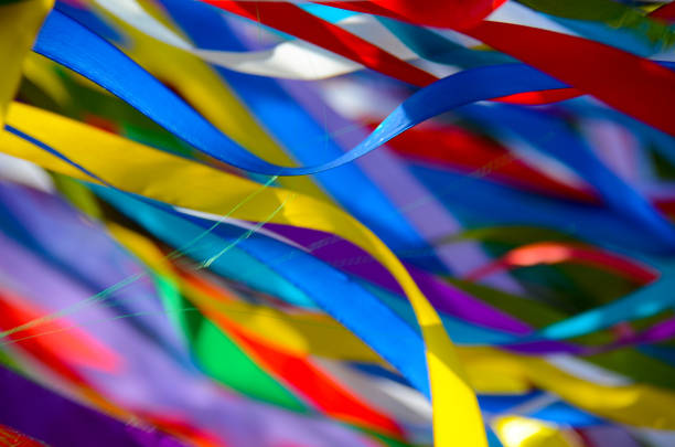 istock Many multicolored ribbons flutter in the wind in the sun. background 1209709307