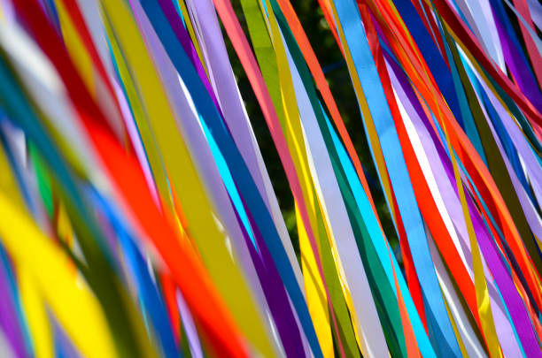 istock Many multicolored ribbons flutter in the wind in the sun. background 1209709322