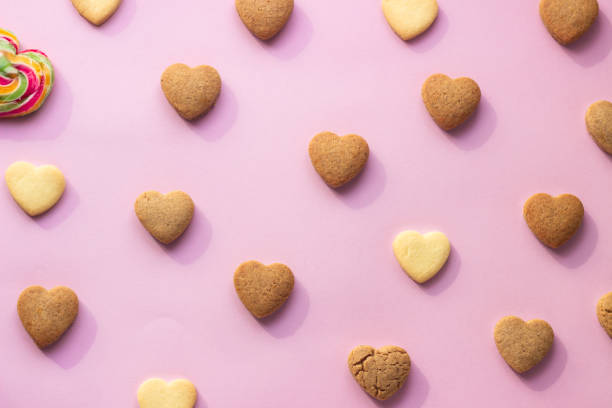 istock Flat lay composition with heart shaped cookies on pink paper background. Cookies pattern, minimal composition. Love concept. Romantic congratulation. 1209713922