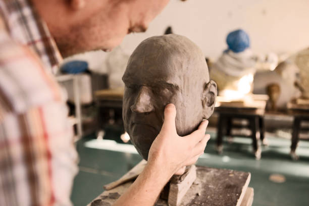 istock Sculptor working on his clay head sculpture molding a shape 1209715071