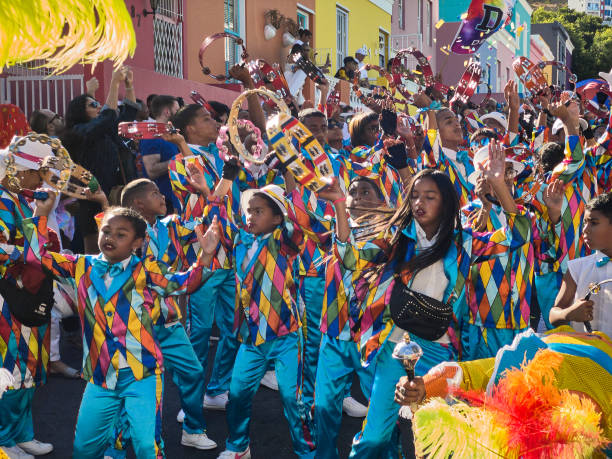 kids dancing and smiling while celebrating at kaapse klopse carnival in cape town on a sunny day Cape Town, South Africa - 02. Januar 2020 people celebrating at kaapse klopse carnival in cape town and walking on street on a sunny day malay quarter photos stock pictures, royalty-free photos & images