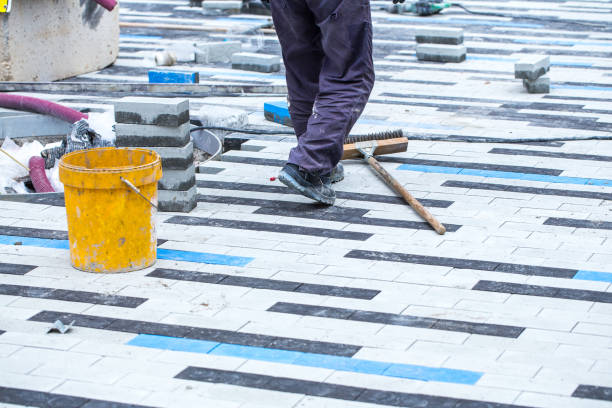 istock Construction work on pavement. Installation of concrete paver blocks on the sidewalk. The worker walks on the unfinished pavement. 1209716458