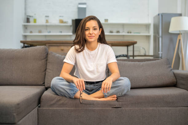 Happy attractive lady resting on sofa in living room