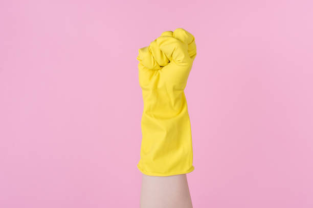 concetto di potenza. foto ravvicinata ritagliata di pugno sollevato in aria isolato sfondo rosa - kitchen glove foto e immagini stock