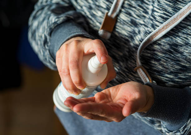istock A woman disinfects her hands 1209722283