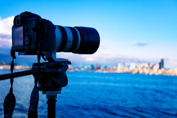 istock Camera on tripod photographing city downtown view 1209722631