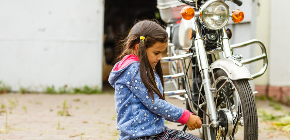 little girl repairing a motorcycle, Student girl in motorbike mechanics