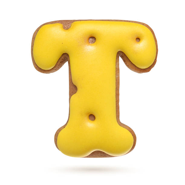 istock Capital letter T yellow gingerbread biscuit isolated on white. 1209723554