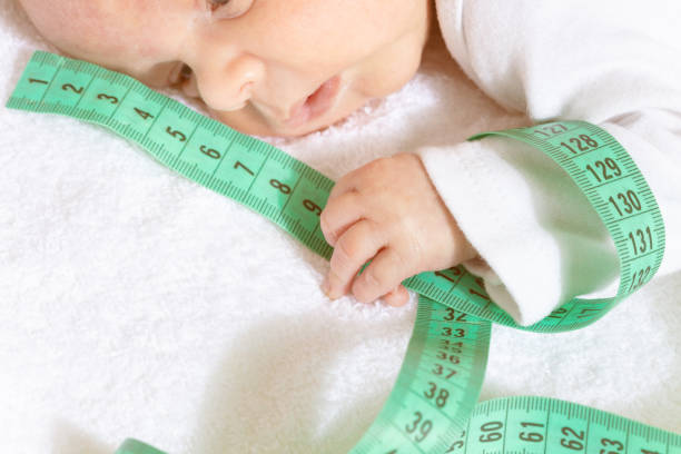 istock Cute baby infant boy hold green centimeter in hand 1209724819