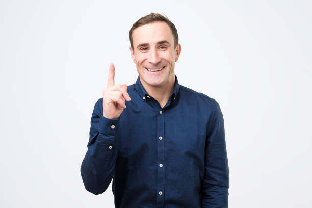 istock man has excited expression, index finger up, recieve good idea for new project work or start up. 1209726766