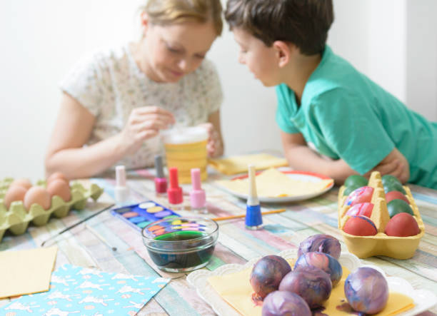 istock Mom and son paints colorful Easter eggs. Family preparing for Easter 1209728497