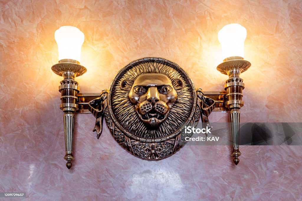 Lion sculpture vintage decoration on the wall Lion sculpture vintage decoration on the wall with lamp Ancient Stock Photo