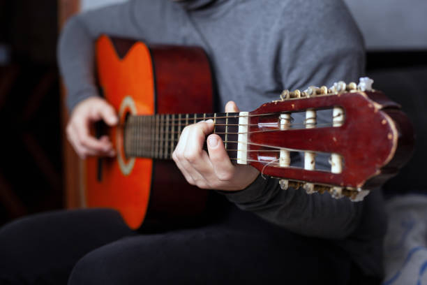 istock girl playing a six string acoustic guitar with nylon strings 1209730011
