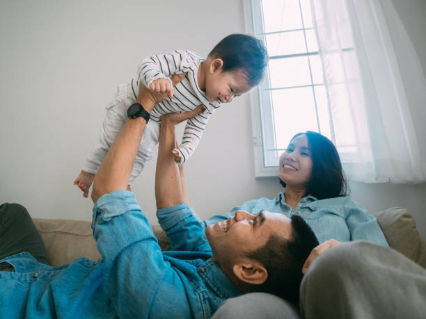 Cute Little Baby Enjoying the Day with Her Mother and Father at Home Asian Parents Having Fun with a Little Baby Boy at Home. 3 6 months stock pictures, royalty-free photos & images