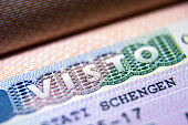 Visa stamp in passport close-up. Italian visitor visa at border control. Macro view of Schengen visa for tourism and travel in EU.