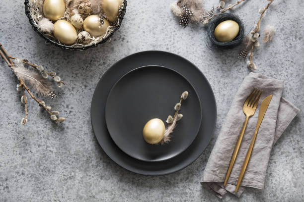 istock Easter table setting with black and golden decor on grey. Top view. 1209732188