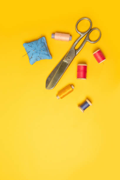 istock Multi colored threads pink reels, measuring tape, sewing machine needles on a background. Sewing accessories for needlework, sewing. 1209732827