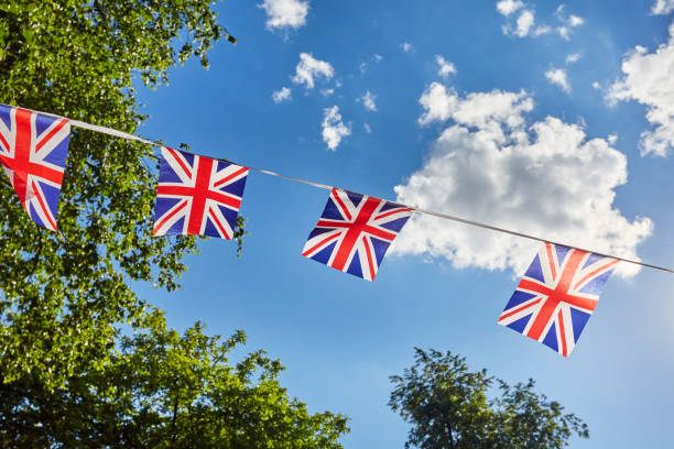 istock British Union Jack bunting flags against sky and green trees 1209732833