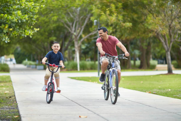 istock Smiling Hispanic Father and Son Riding Bicycles in Miami 1209737044