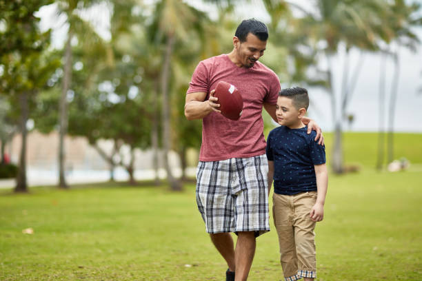 istock Smiling Hispanic Father and Son Enjoying Weekend Football 1209737052