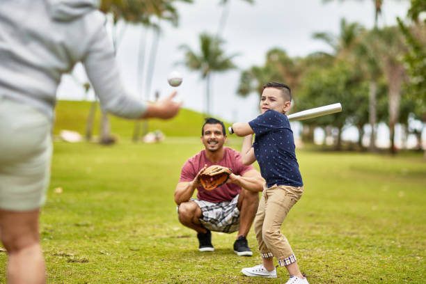 garçon hispanique prêt à balancer au terrain de base-ball dans le parc de miami - baseball hitting baseball player child photos et images de collection