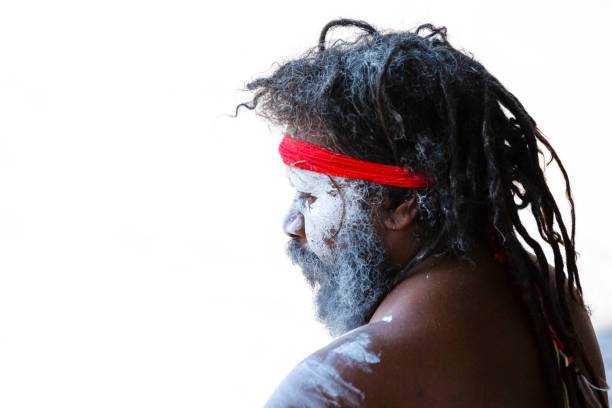 retrato de macho aborígene com dreadlocks e faixa vermelha, vista lateral, fundo branco com espaço de cópia - aborigine didgeridoo indigenous culture australia - fotografias e filmes do acervo