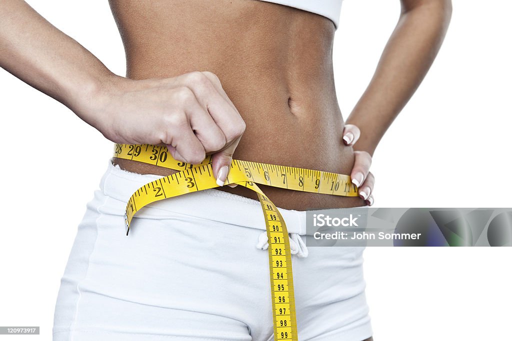 Woman measuring her waist Woman measuring her waist shot on white 20-29 Years Stock Photo