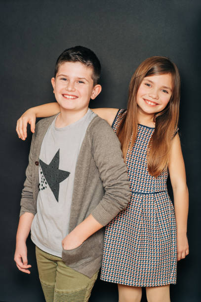 istock Studio portrait of two cute kids, posing on black background 1209743479