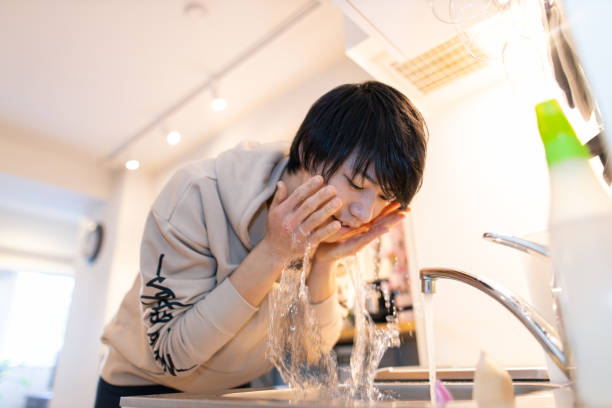 istock Young man washing face in the morning 1209743745
