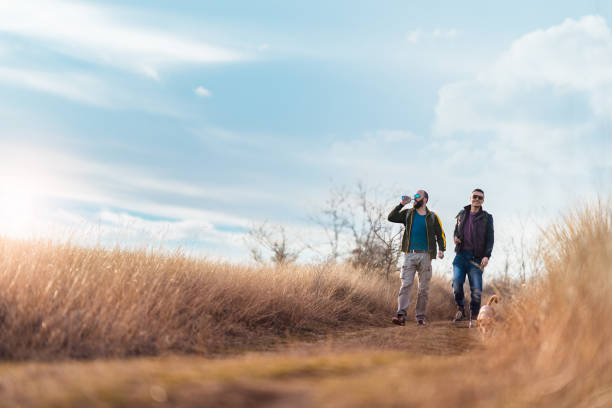 istock Happy friends walking with a dog 1209746350