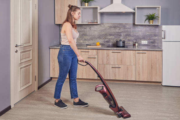 istock Maid uses wireless vacuum cleaner in the kitchen. 1209748128